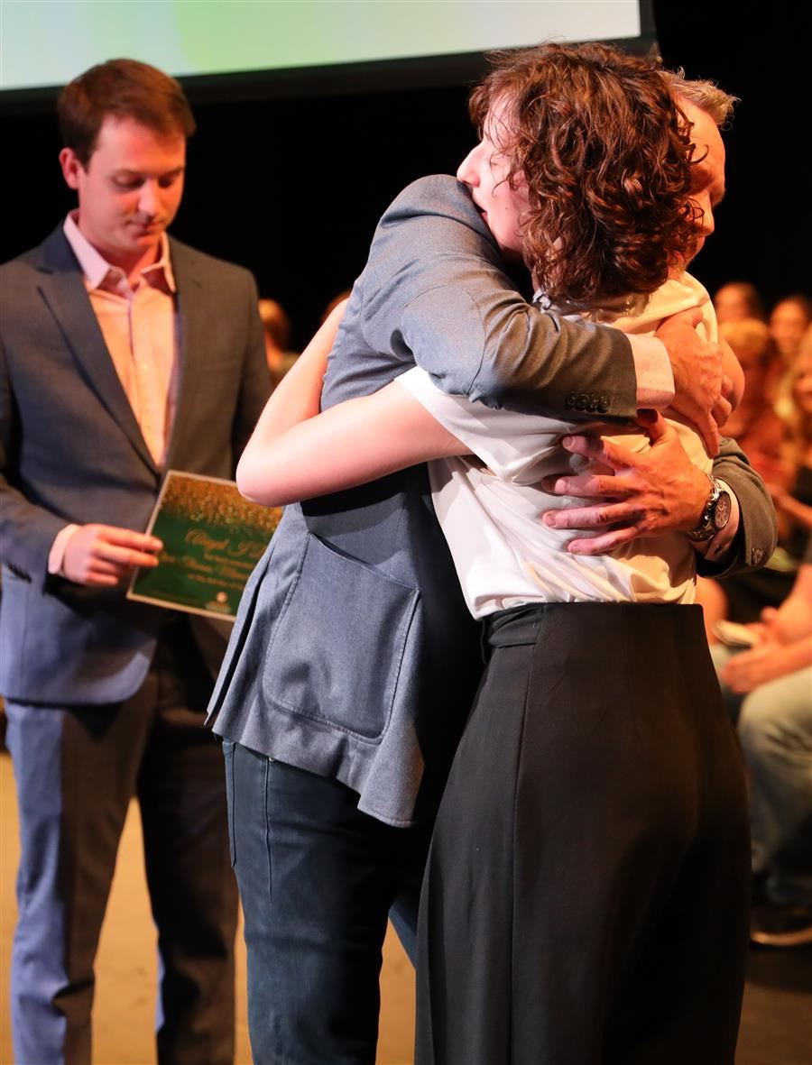  A female student receives a congratulatory hug after accepting a scholarship.